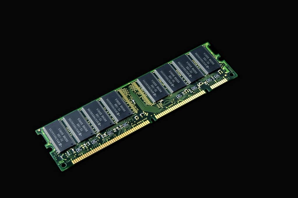 Computer RAM memory module stick against a black background representing component costs. 
