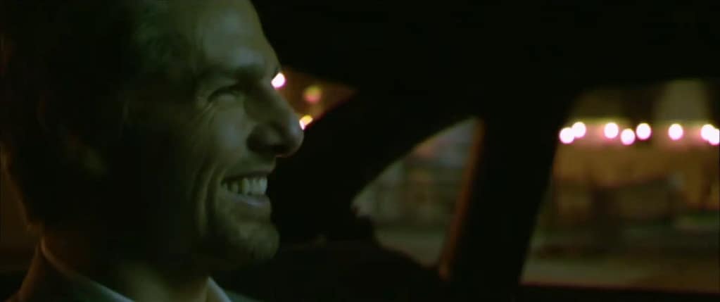 Tom Cruise laughing coldly inside a car as the hitman Vincent in Michael Mann’s Collateral (2004). Image credit: Collateral (2004) - film still via Rotten Tomatoes Classic Trailers/YouTube.