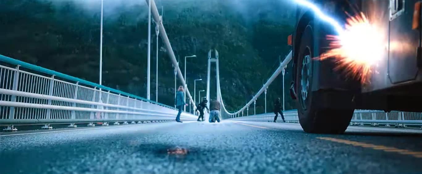 A wide shot of Eric (Nat Wolff) kneeling on a bridge as lightning strikes a truck; screenshot via One Media.