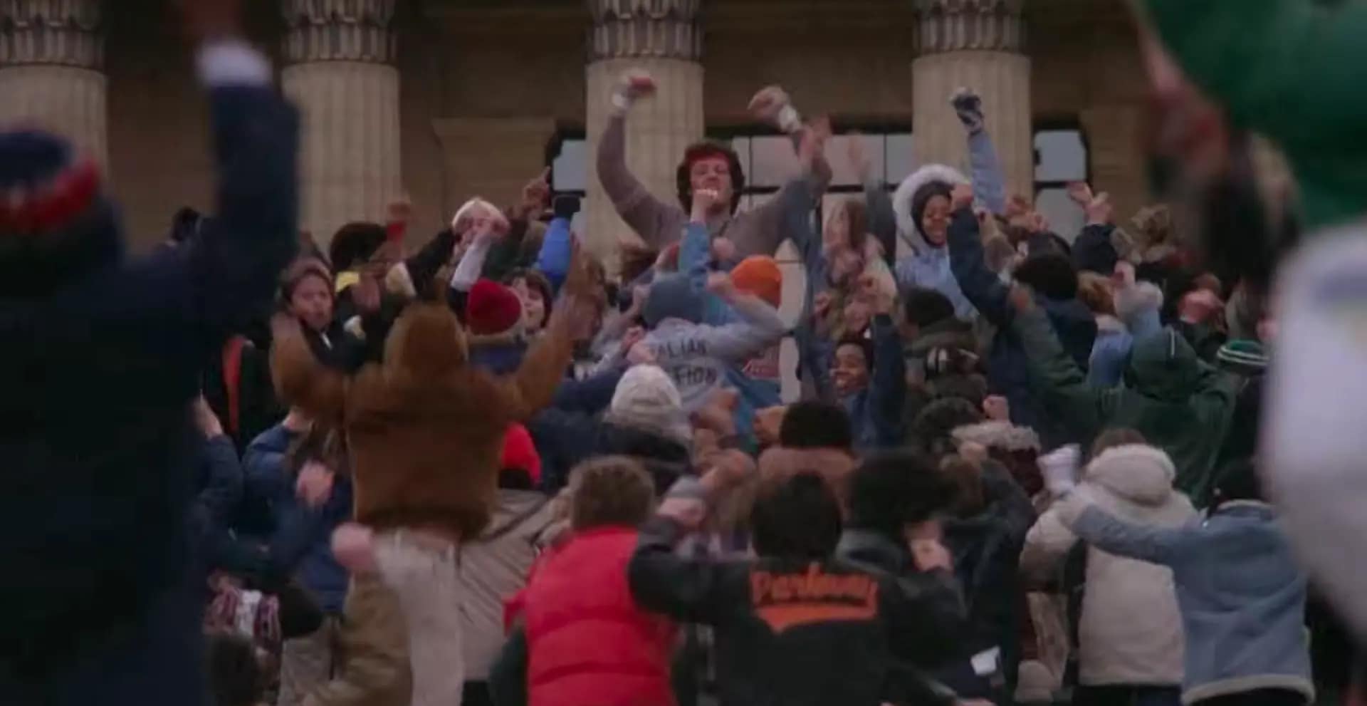 Sylvester Stallone as Rocky Balboa celebrating with a massive crowd of people on the Philadelphia museum steps. Image credit: Rocky II - film still via Official Rocky Balboa/YouTube.