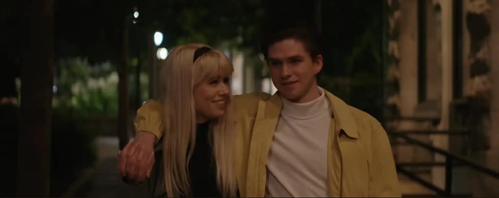 Warden Wayne as Peter Parker walking arm-in-arm with Tuyen Powell as Gwen Stacy during a heartfelt night flashback sequence. 