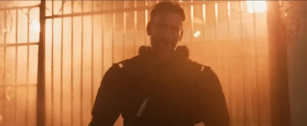 Deputy (Phil “CM Punk” Brooks) backlit by foggy streetlights in a grainy night scene from Night Patrol. Image credit: Night Patrol film still - via Rotten Tomatoes Trailers/YouTube.