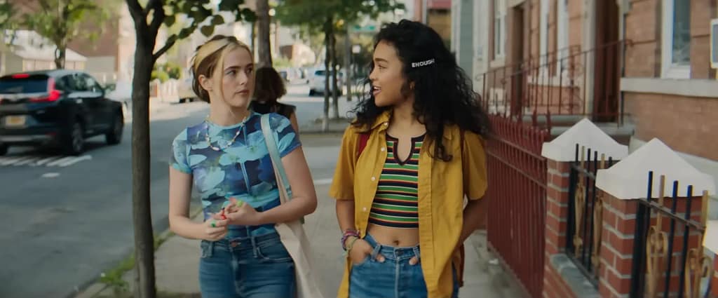 Danni Sanders and activist Rowan Aldren walking together on a city street in a scene from Not Okay (2022).