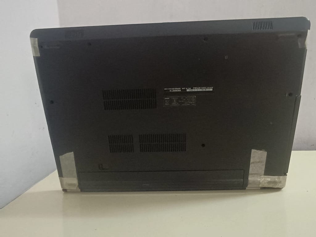 The bottom panel of a laptop reinforced with tape to keep the chassis closed.