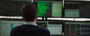 Jesse Eisenberg as Vincent Zaleski sitting in front of multiple monitors tracking high-frequency trading data in The Hummingbird Project. Image credit: The Hummingbird Project (2018) film still - via Rotten Tomatoes Trailers/YouTube.