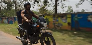 Kapil Sharma as Manas Mahto riding a motorcycle with a food delivery bag in Zwigato (2022).
