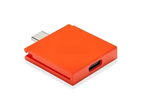 An orange Framework Laptop USB-C Expansion Card showing the modular port design.